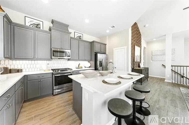 A kitchen with a white counter top and grey cabinets.