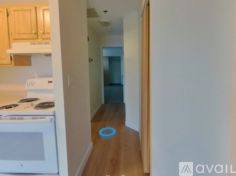 A kitchen with a white stove and wooden cabinets.