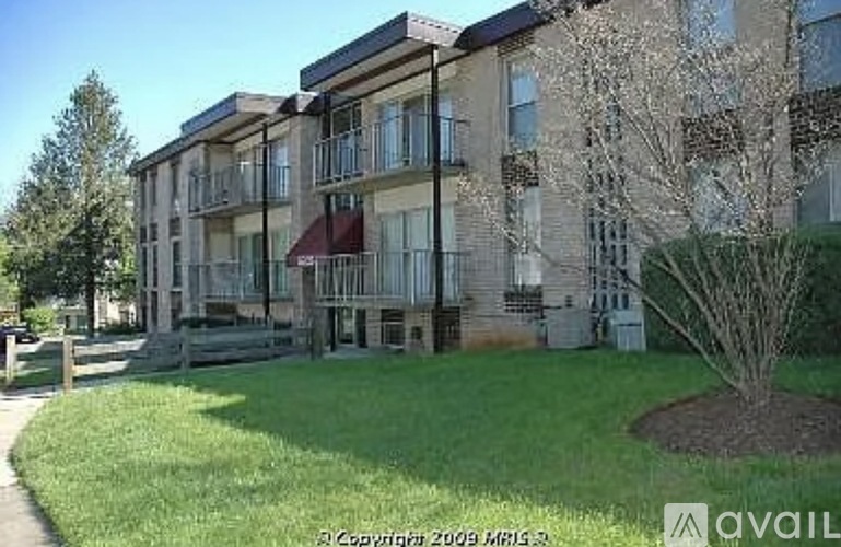 Apartment building with a tree in front of it.