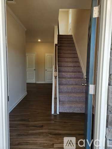 A hallway with a staircase leading to the second floor.