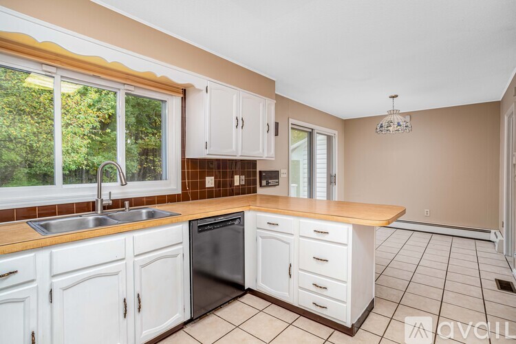 A kitchen with white cabinets and a wooden countertop.