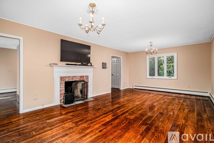 A living room with a fireplace and a television on the wall.