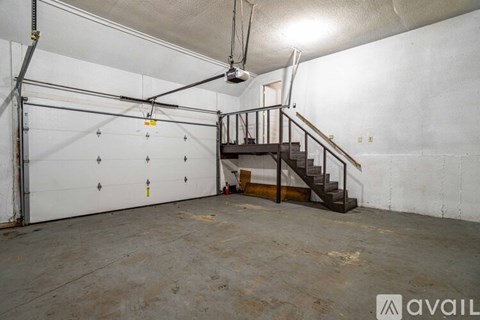 A spacious garage with a staircase and a ceiling fan.