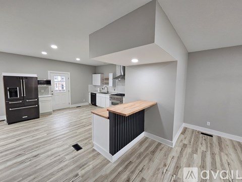 A modern kitchen with a wooden island and stainless steel appliances.