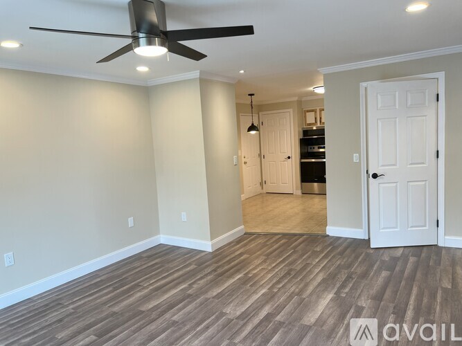A room with a ceiling fan and wooden flooring.