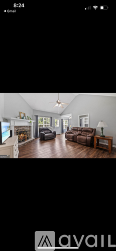 A living room with a white ceiling fan and wooden floors.