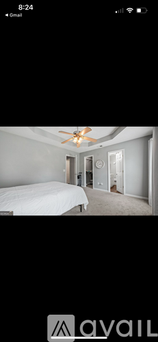 A bedroom with a bed, dresser, and ceiling fan.
