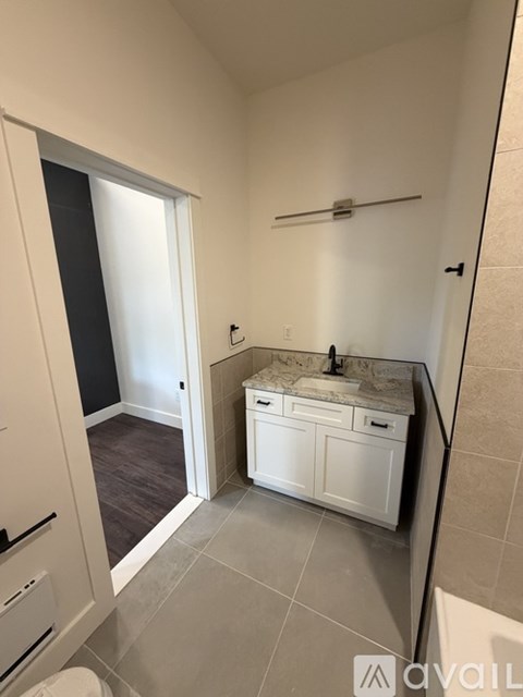A bathroom with a sink, toilet, and a mirror.