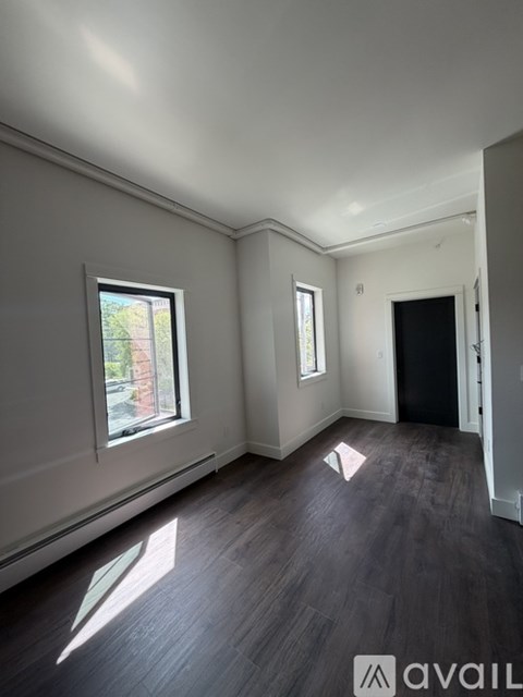 A room with a window and a door is available for rent.