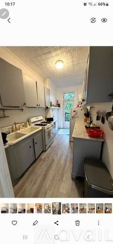 A kitchen with white cabinets and a wooden floor.