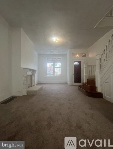 A spacious room with a staircase and a window.
