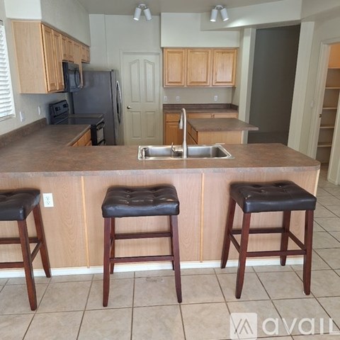 A kitchen with a bar stool in front of a counter.
