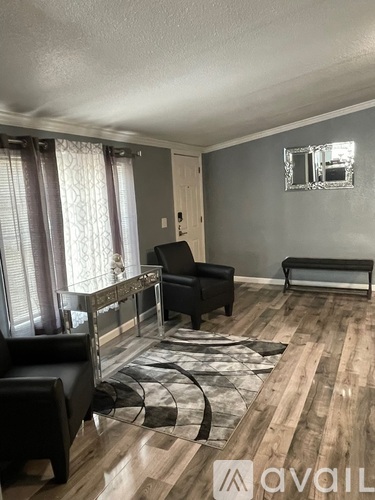 A living room with a black leather chair and a glass coffee table.