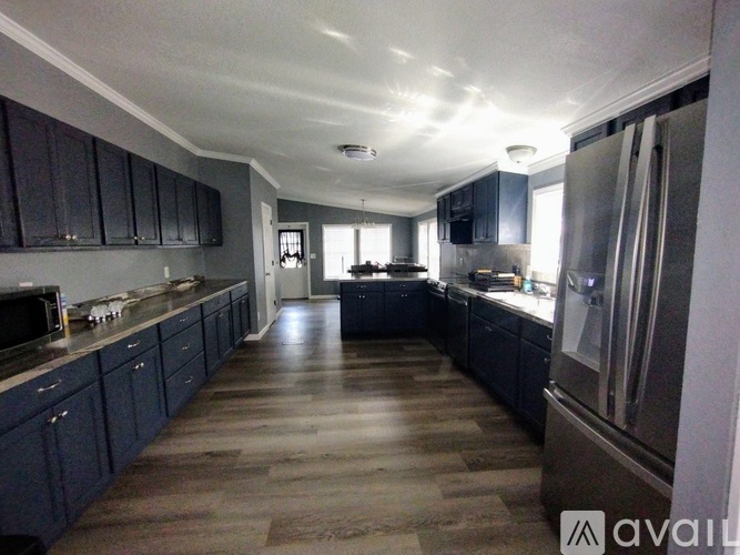 A kitchen with dark wood cabinets and a long counter.