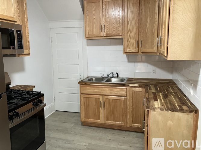 A kitchen with wooden cabinets and a black stove top.