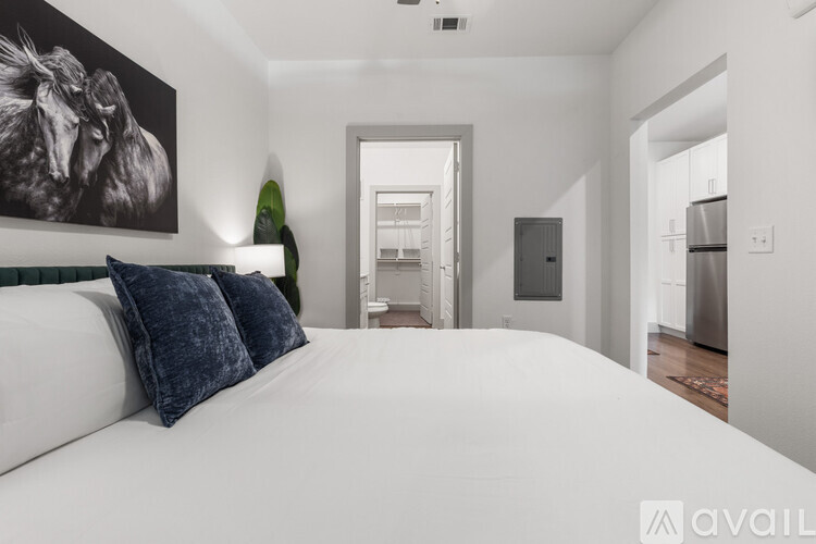 A bedroom with a large bed and a painting on the wall.