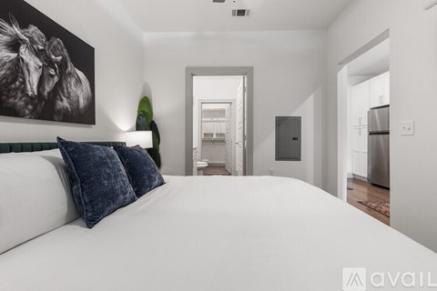A bedroom with a large bed and a painting on the wall.