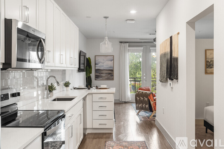 A kitchen with white cabinets and a black stove top oven.