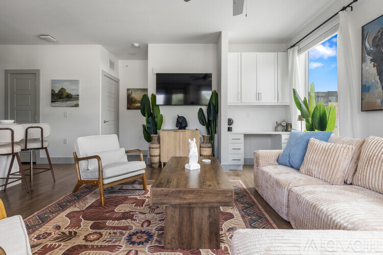A living room with a white couch, a wooden coffee table, and a rug with a pattern.