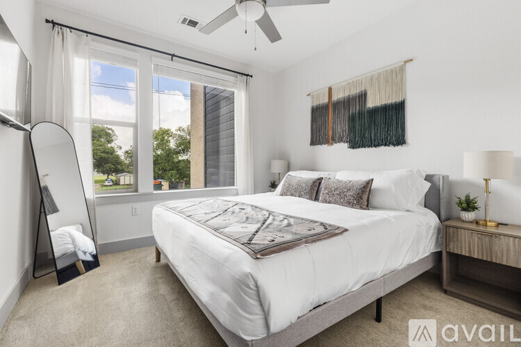 A bedroom with a large bed and a window with a view of trees.