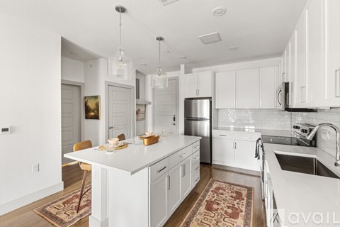 A kitchen with white cabinets and a white island.