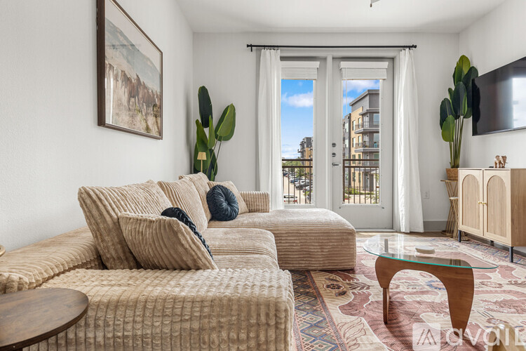 A living room with a couch, a coffee table, and a painting on the wall.