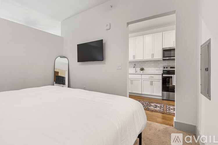 A bedroom with a large bed and a television mounted on the wall.