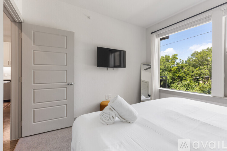 A bedroom with a large bed and a flat screen TV mounted on the wall.