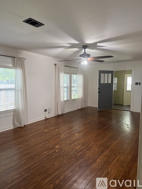 A room with wooden floors and a ceiling fan.