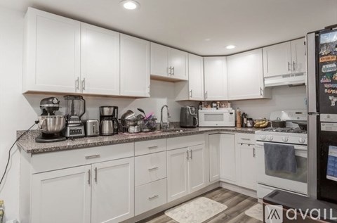 A kitchen with white cabinets and appliances.