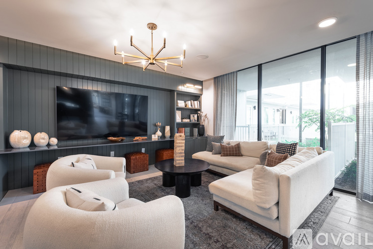 A modern living room with a large television and comfortable seating.