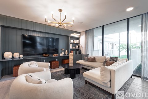 A modern living room with a large television and comfortable seating.