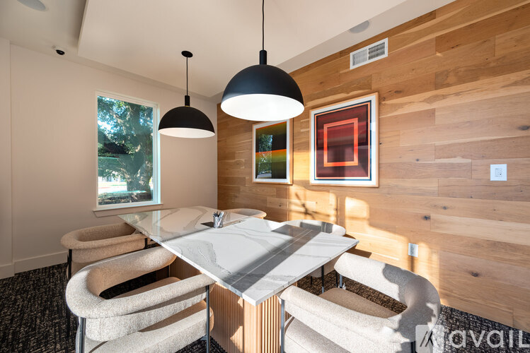 A modern dining room with a wooden wall and a glass table.