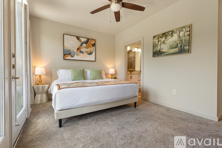 A bedroom with a large bed and a ceiling fan.
