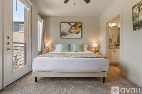 A bedroom with a large bed and a painting on the wall.