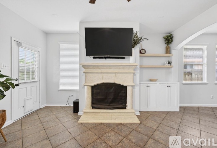 A living room with a fireplace and a television above it.