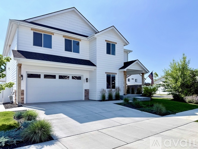 A two-story house with a white exterior and a black roof.