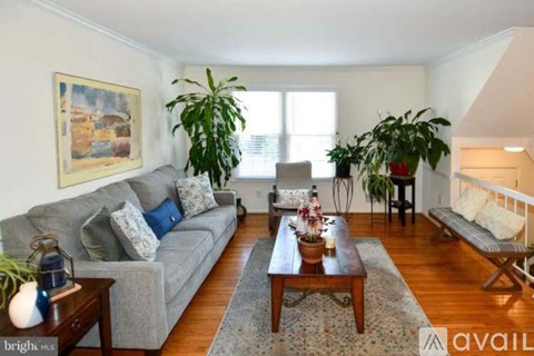 A living room with a grey couch, a coffee table, and a painting on the wall.