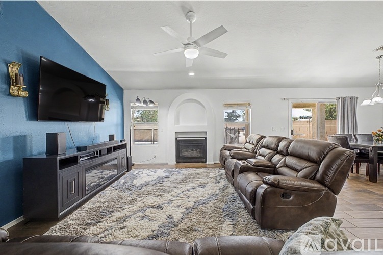 A living room with a brown leather couch and a fireplace.