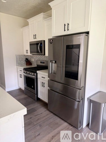 A kitchen with a stainless steel refrigerator and oven.