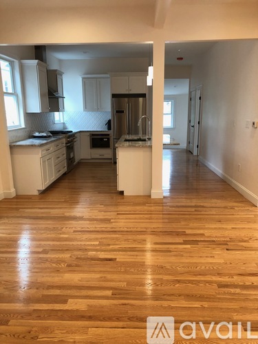 A kitchen with wooden floors and white cabinets.