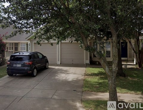 A car is parked in a driveway in front of a house.