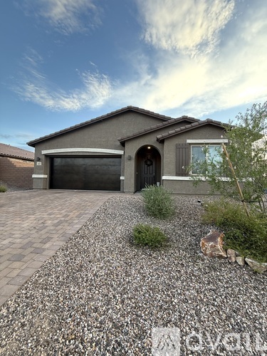 A house with a grey roof and a black garage door.