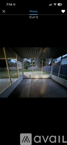 A photo gallery app interface showing a photo of a room with a wooden floor and a glass wall.