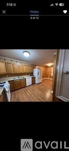 A kitchen with wooden cabinets and a white refrigerator.