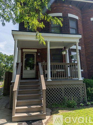 A house with a front porch and stairs leading to the door.