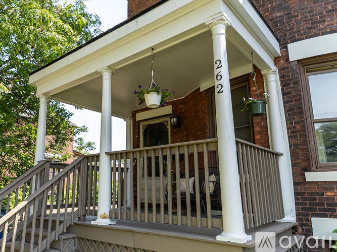 A porch with a white railing and pillars with the numbers 262 on them.