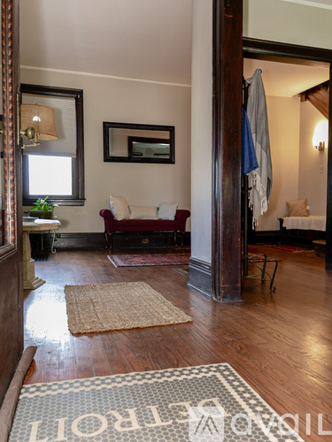 A living room with a rug on the floor that says "Welcome".