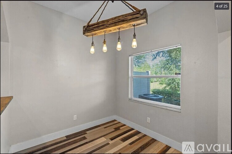 A room with a window showing a view of a body of water and trees.