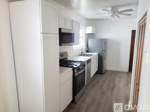 A kitchen with white cabinets and a black stove top.